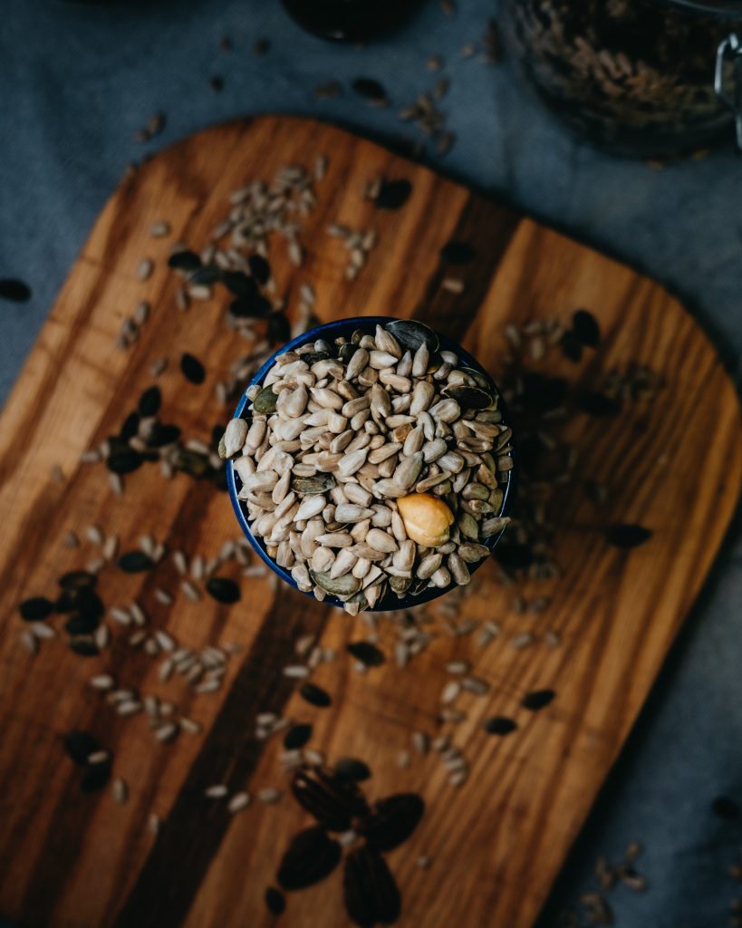 Image of a bowl containing nuts and seeds.  Nuts and seeds are great whole food magnesium sources and can help boost magnesium levels to combat stress.